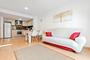 a living room with a white couch and a kitchen at Canana De Vega in Flix