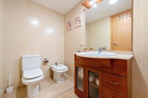 a bathroom with a white toilet and a sink at Canana De Vega in Flix +16 photos