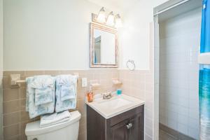 a bathroom with a sink and a toilet and a mirror at pink peacock in Holmes Beach +5 photos