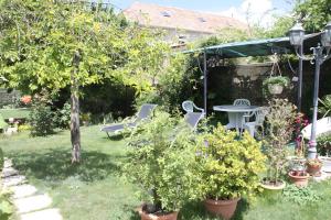 a garden with a table and chairs and trees at Gîte De Diane in Allemagne-en-Provence +6 photos