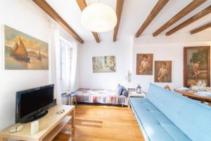 a living room with a blue couch and a tv at Contessa di Corfu ii in Corfu