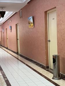 an empty hallway of a building with pink walls at Hotel Tiznit in Tiznit