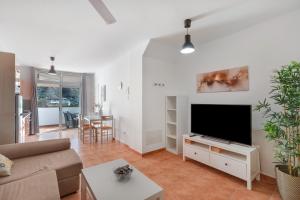 a living room with a couch and a flat screen tv at Vv Estrella in Puerto de Mogán