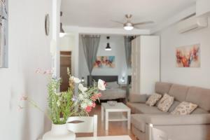 a living room with a couch and a table with flowers at Vv Estrella in Puerto de Mogán