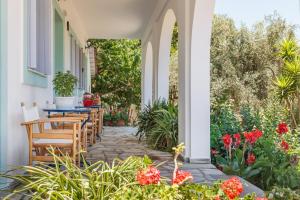 an outdoor patio with tables and chairs and flowers at Artemis Bungalows in Stafylos