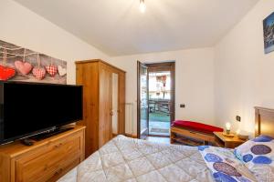 a bedroom with a flat screen tv and a bed at Gioiello Col de Joux in Saint Vincent