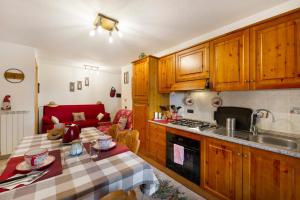 a kitchen with wooden cabinets and a table with at Gioiello Col de Joux in Saint Vincent