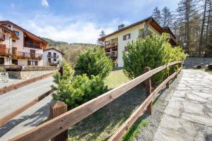 a house with a wooden fence and some bushes at Gioiello Col de Joux in Saint Vincent