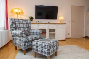 a living room with a chair and a tv at Ferienparadies Bodensee Fewo1 in Owingen