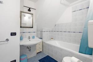 a bathroom with a sink and a tub and a toilet at Lisettarooms in Vernazza