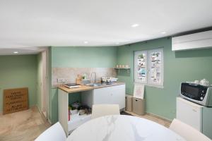 a kitchen with green walls and a table and chairs at Civico 32 in Salerno