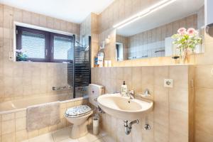 a bathroom with a sink and a toilet and a tub at Blütenzauber in Todtnau +21 photos