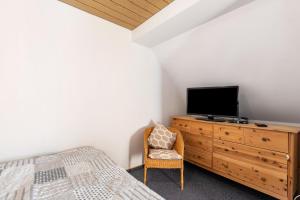 a bedroom with a bed and a tv on a dresser at Whg 1- Ferien auf einem Resthof in Schönhagen