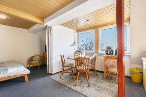 a room with a table and chairs and a bedroom at Whg 1- Ferien auf einem Resthof in Schönhagen