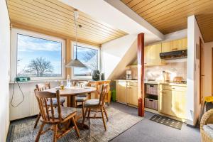 a kitchen and dining room with a table and chairs at Whg 1- Ferien auf einem Resthof in Schönhagen