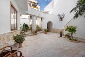 a courtyard of a white building with plants and a street light at Il Cortiletto 21 in Marsala