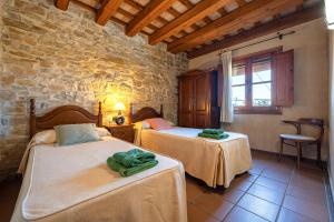 a bedroom with two beds and a stone wall at El Clos 1 in Conesa +34 photos