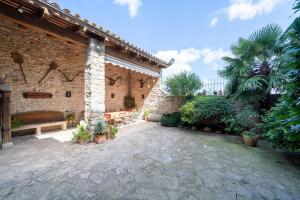 a courtyard of a building with a bench and plants at El Clos 1 in Conesa