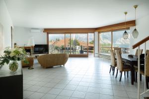 a living room with a table and chairs at Panorama Apartment 180 mq in Nago-Torbole