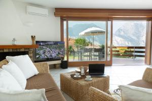 a living room with a couch and a laptop on a table at Panorama Apartment 180 mq in Nago-Torbole