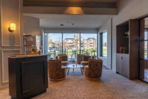 a room with chairs and a table and a large window at Hotel de Zon - Brasserie Bresson by Flow in Ommen