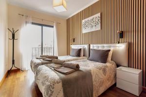 a bedroom with two beds and a large window at Moradia Casa Feliz in Santa Cruz