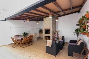 a living room with a table and chairs and a fireplace at Moradia Casa Feliz in Santa Cruz