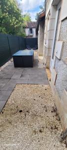 a patio with a bench sitting next to a building at Logement Douce évasion in Saint-Julien-lʼArs