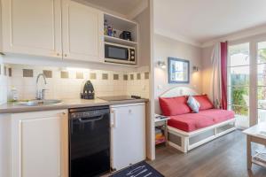 a kitchen with a sink and a couch in a room at L' Eclose Cap Marine in Le Guilvinec