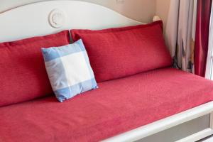 a red couch with a blue and white pillow on it at L' Eclose Cap Marine in Le Guilvinec +22 photos