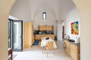 a kitchen with a table and a dining room at Casa Pizzicchia in Muro Leccese