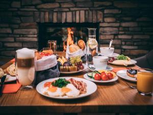 a table with plates of breakfast food and a fireplace at Ferienhaus im Trixi Ferienpark in Großschönau