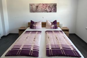 two beds in a bedroom with purple and purple blankets at Ferienwohnung S Keller in Plankenfels