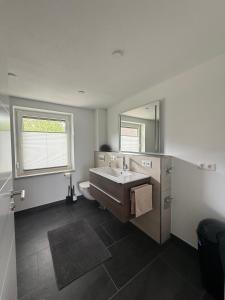 a bathroom with a tub and a sink and a mirror at Ferienwohnung S Keller in Plankenfels +16 photos