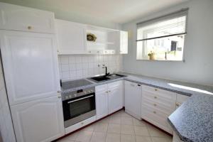 a kitchen with white cabinets and a sink and a window at Ferienwohnung No15 in Pfullendorf +15 photos