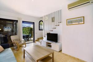 a living room with a television and a table at Meloneras 1 in Maspalomas