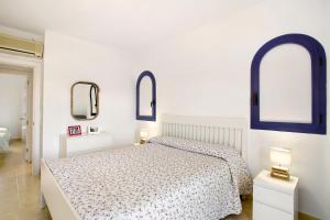 a white bedroom with two windows and a bed at Meloneras 1 in Maspalomas +21 photos