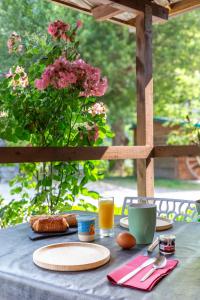 a table with plates of food and a vase with pink flowers at Tiny house au coeur de la nature in Touët-sur-Var +9 photos