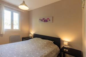 a bedroom with a bed and two tables and a window at Gîte Chêne ou Murier in Les Vans +23 photos