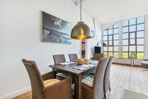 a dining room with a table and chairs at Wat'n Utkiek in Rodenäs