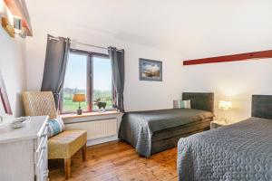 a bedroom with two beds and a window at Wat'n Utkiek in Rodenäs