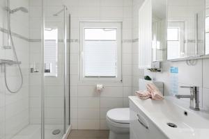 a white bathroom with a toilet and a shower at Kleines Schweden in Hennstedt +18 photos