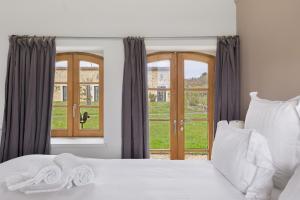 a bedroom with a white bed and a window at Petit Prépinson - La Trigalière in Ambillou +25 photos