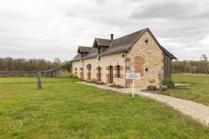 an old brick building with a sign in a field at Petit Prépinson - La Trigalière in Ambillou