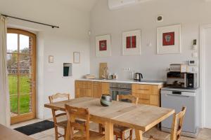 a kitchen with a wooden table and some chairs at Petit Prépinson - La Trigalière in Ambillou