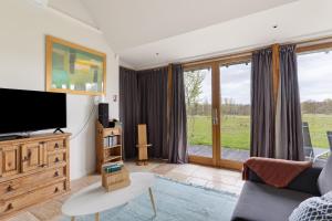 a living room with a tv and a couch at Petit Prépinson - La Trigalière in Ambillou