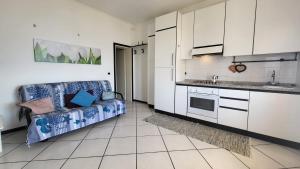 a kitchen with white cabinets and a couch in a room at Appartamento Bellavista in Capoliveri +8 photos
