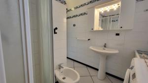 a white bathroom with a sink and a toilet at Appartamento Bellavista in Capoliveri