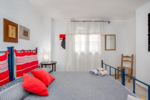 a bedroom with a bed with red pillows and a window at 6 Appartamento Molara in San Teodoro +18 photos