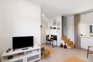 a living room with a flat screen tv on a white cabinet at Casa Barroca in Alte